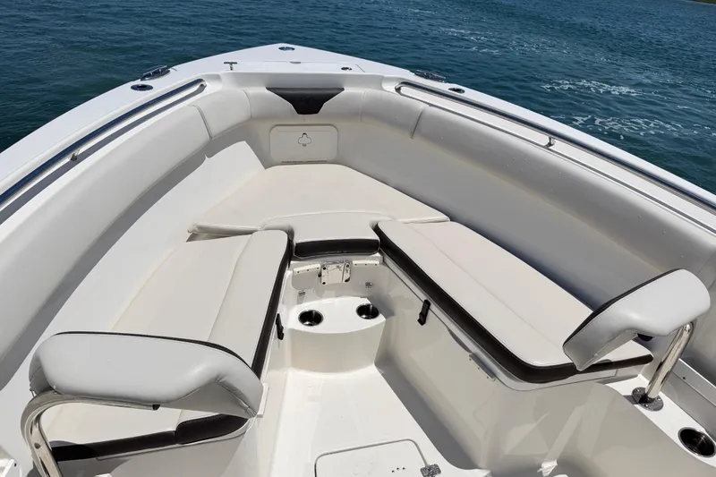 Slide: The Image of 2021 Sailfish 290 CC boat interior with cushioned seating and ocean view. - 21