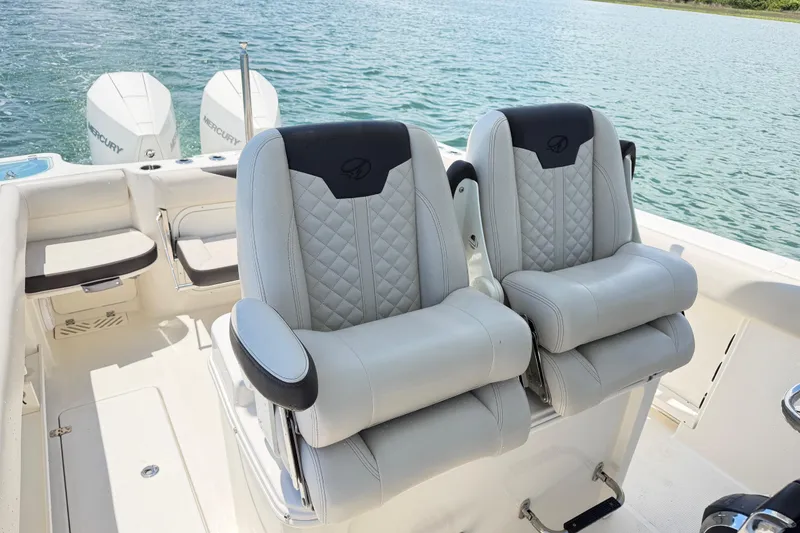 Slide: The Image of 2021 Sailfish 290 CC boat interior with dual cushioned seats and Mercury engines. - 31