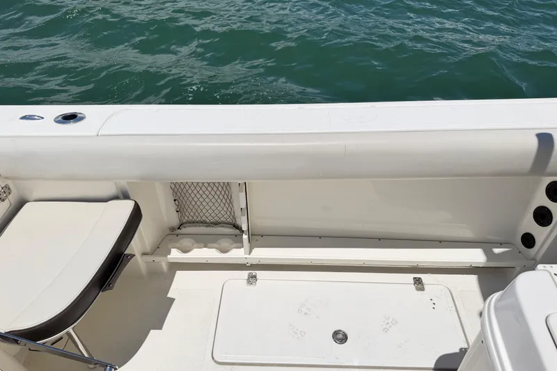 Slide: The Image of 2021 Sailfish 290 CC boat interior with seating and storage, near water. - 36