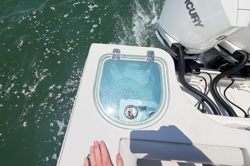 Slide: The Image of 2021 Sailfish 290 CC boat with livewell and Mercury engine on water. - 38