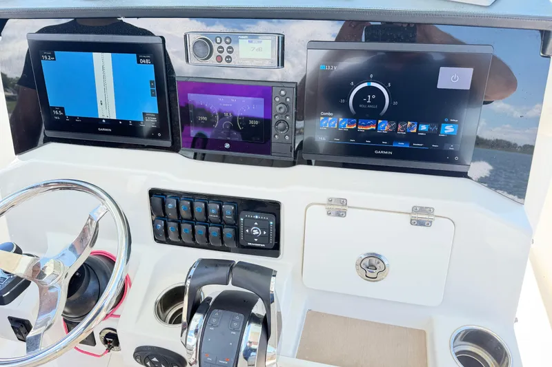 Slide: The Image of 2021 Sailfish 290 CC boat dashboard with Garmin navigation displays and controls. - 43