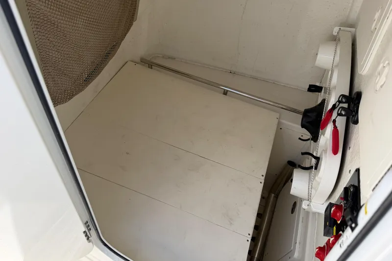Slide: The Image of Interior view of a 2021 Sailfish 290 CC boat compartment with storage and controls. - 44