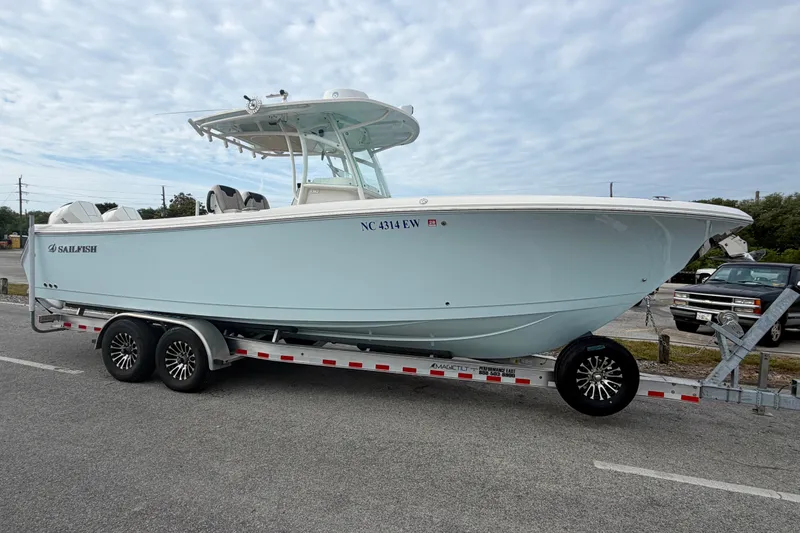 Slide: The Image of 2021 Sailfish 290 CC boat on trailer, parked outdoors under cloudy sky. - 46