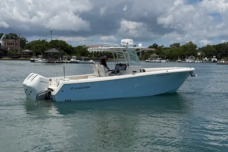 Slide: The Image of 2021 Sailfish 290 CC boat cruising on a calm lake with scenic background. - 5