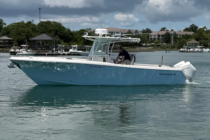 Slide: The Image of 2021 Sailfish 290 CC boat cruising on a calm waterway with scenic background. - 9