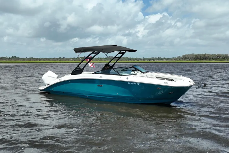 The Image of 2024 Sea Ray SDX 270 Outboard boat cruising on a calm lake under cloudy skies. - 0