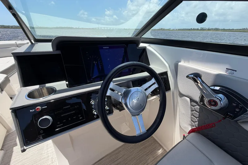 Slide: The Image of 2024 Sea Ray SDX 270 Outboard helm with steering wheel and control panel. - 17