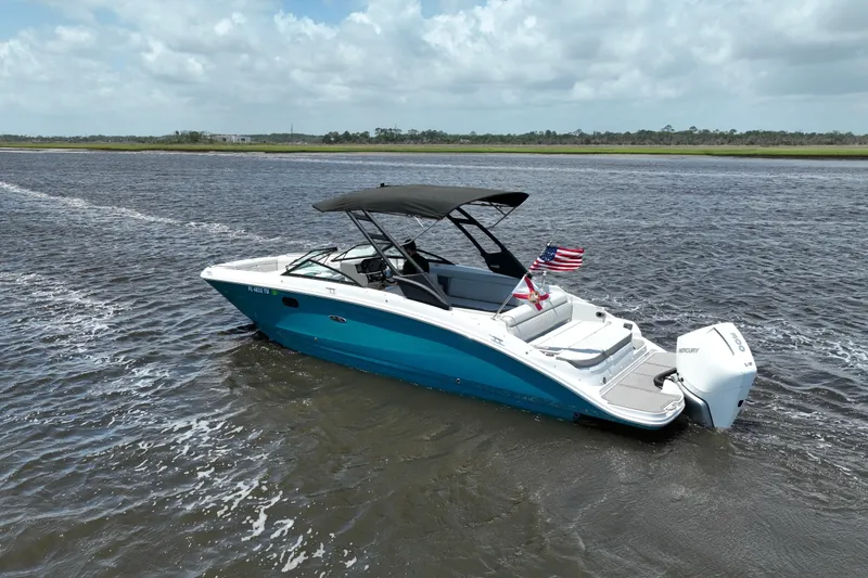Slide: The Image of 2024 Sea Ray SDX 270 Outboard boat cruising on a scenic waterway. - 2