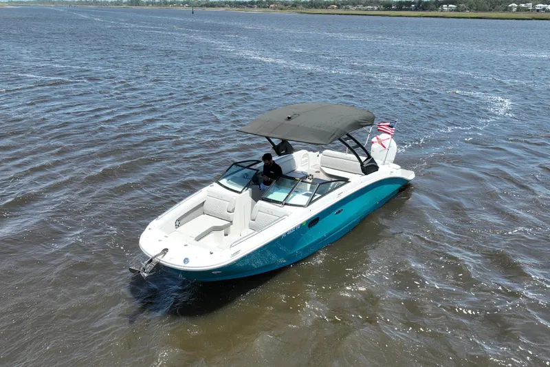 Slide: The Image of 2024 Sea Ray SDX 270 Outboard boat cruising on open water with canopy and American flag. - 4