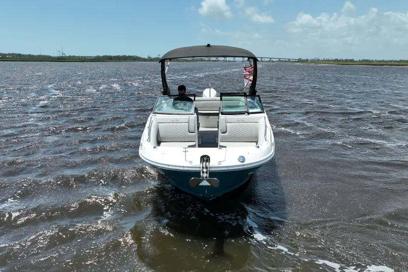 Slide: The Image of 2024 Sea Ray SDX 270 Outboard boat cruising on open water under a clear sky. - 8