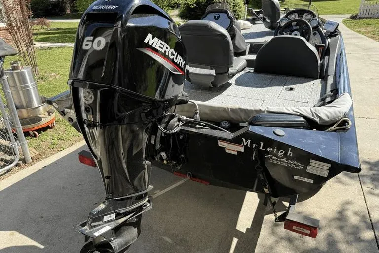 Slide: The Image of 2023 Tracker Pro Team 175 TX boat with Mercury 60 outboard motor, parked on driveway. - 5