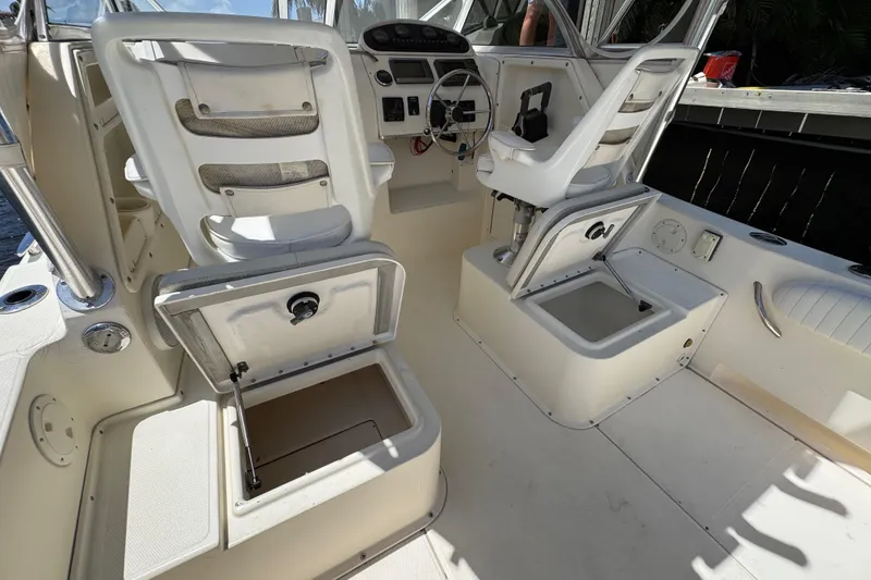 Slide: The Image of 2003 World Cat 270 EC boat interior with open storage compartments and helm seating. - 1