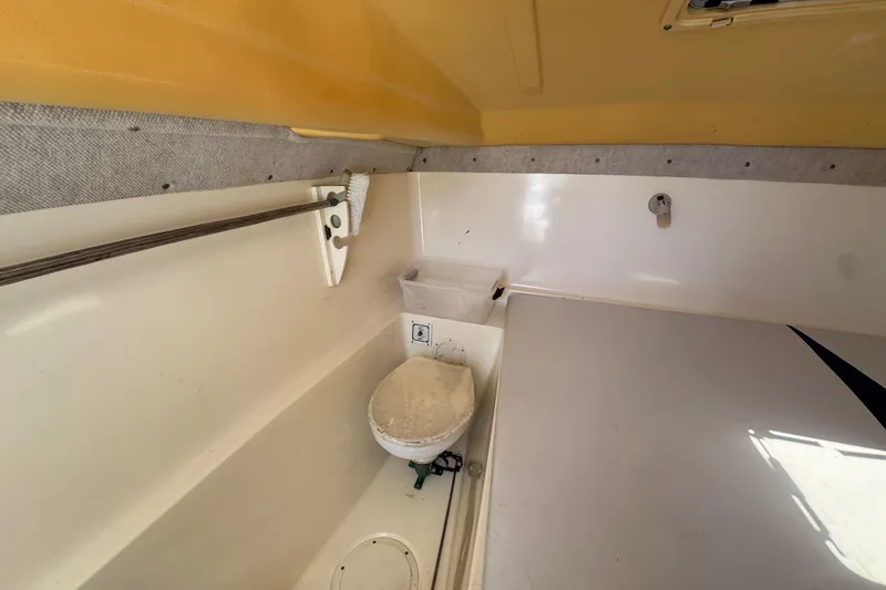 Slide: The Image of Interior of 2003 World Cat 270 EC boat showing compact bathroom with toilet. - 19