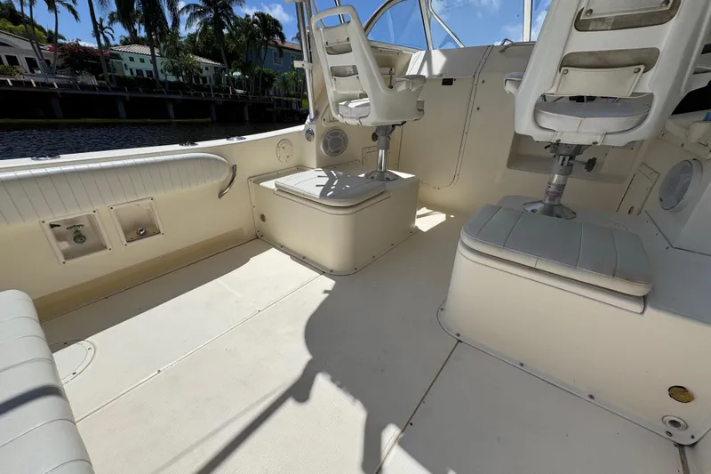 Slide: The Image of 2003 World Cat 270 EC boat interior with seating and helm, dockside view. - 2