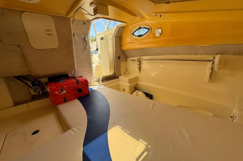 Slide: The Image of Interior cabin of a 2003 World Cat 270 EC boat, featuring seating and storage. - 21