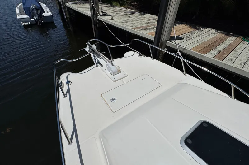 Slide: The Image of 2003 World Cat 270 EC boat docked, featuring spacious deck and railing. - 24