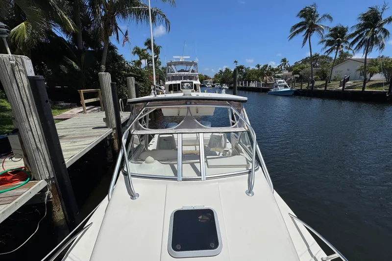 Slide: The Image of 2003 World Cat 270 EC docked by a canal with palm trees and clear sky. - 26