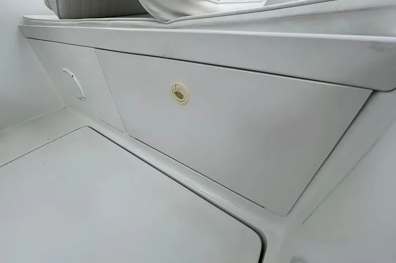 Slide: The Image of Storage compartment on a 1996 Luhrs Tournament 290 Open boat, featuring sleek white design. - 27