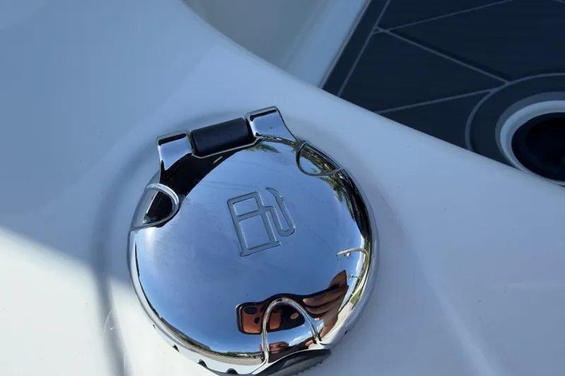 Slide: The Image of Chrome fuel cap on a 2021 Tahoe 1950 boat, reflecting surroundings. - 99