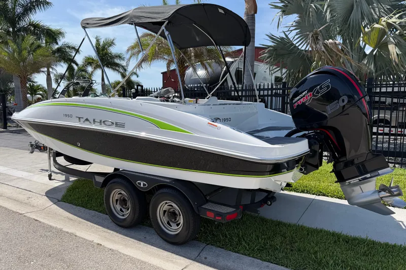 Slide: The Image of 2021 Tahoe 1950 boat with Mercury Pro XS engine on trailer, parked near palm trees. - 3