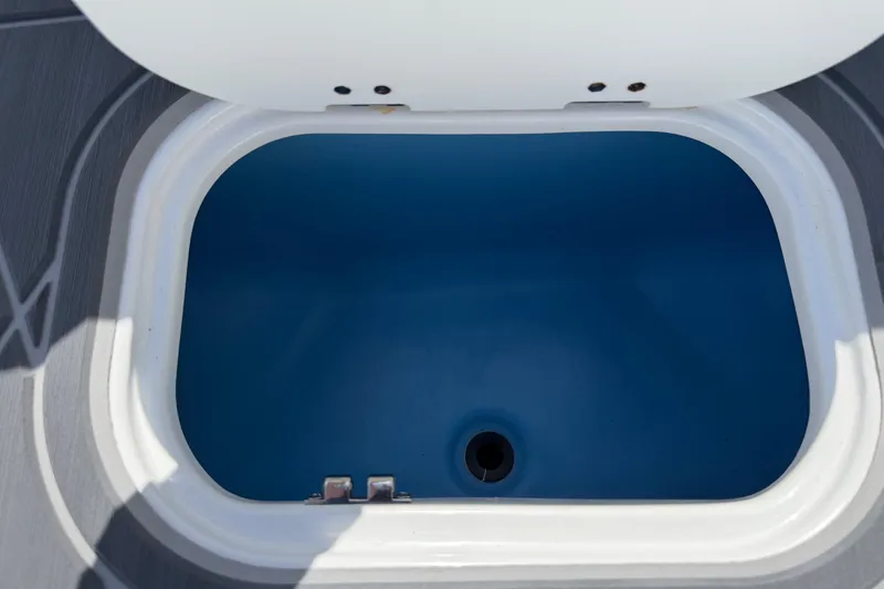 Slide: The Image of Open storage compartment in a 2021 Tahoe 1950 boat, featuring a blue interior. - 62