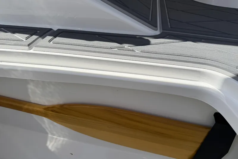Slide: The Image of Close-up of a 2021 Tahoe 1950 boat deck with wooden paddle detail. - 84