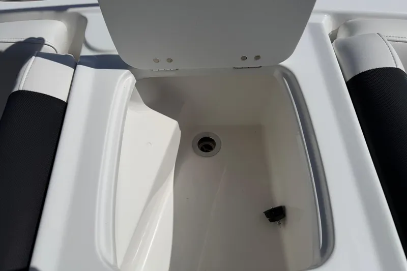 Slide: The Image of Open storage compartment on a 2021 Tahoe 1950 boat, featuring a drain plug. - 75