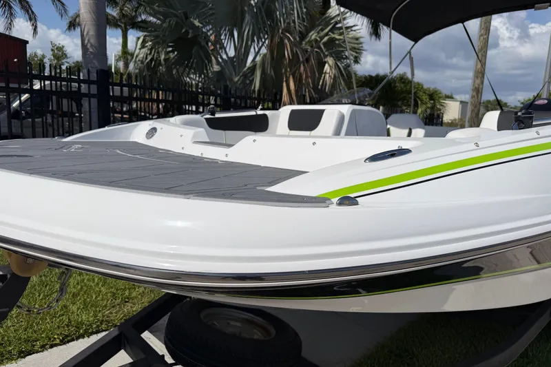 Slide: The Image of 2021 Tahoe 1950 boat with sleek design, white and green accents, parked outdoors. - 29