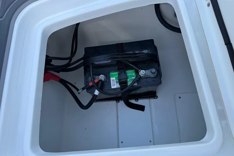 Slide: The Image of Battery compartment of a 2021 Tahoe 1950 boat, featuring secured wiring and connections. - 97