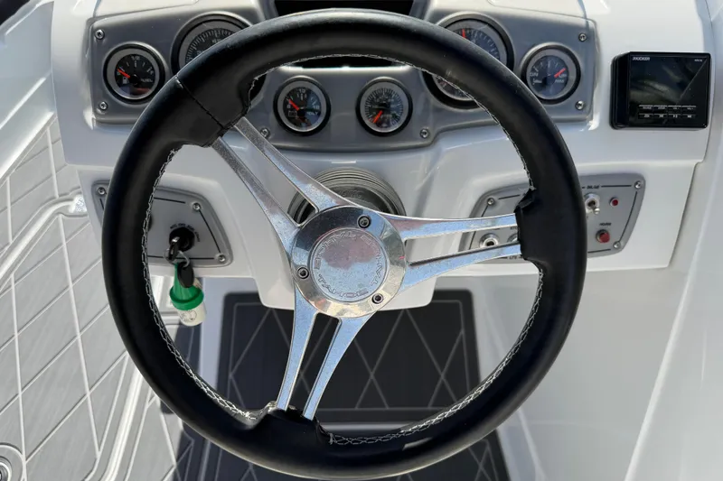 Slide: The Image of Steering wheel and dashboard of a 2021 Tahoe 1950 boat, featuring gauges and controls. - 50
