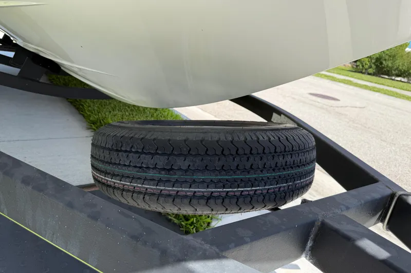 Slide: The Image of Trailer tire under a 2021 Tahoe 1950 boat on a sunny day. - 28