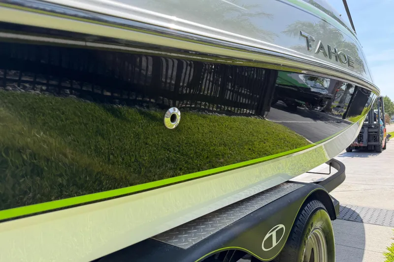 Slide: The Image of 2021 Tahoe 1950 boat on trailer, sleek design with green accents, parked outdoors. - 17