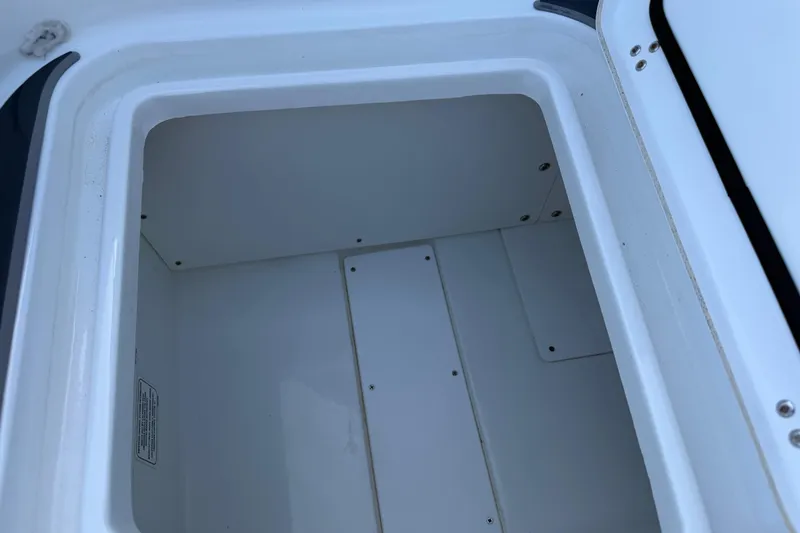Slide: The Image of Open storage compartment in a 2021 Tahoe 1950 boat, featuring a clean white interior. - 7