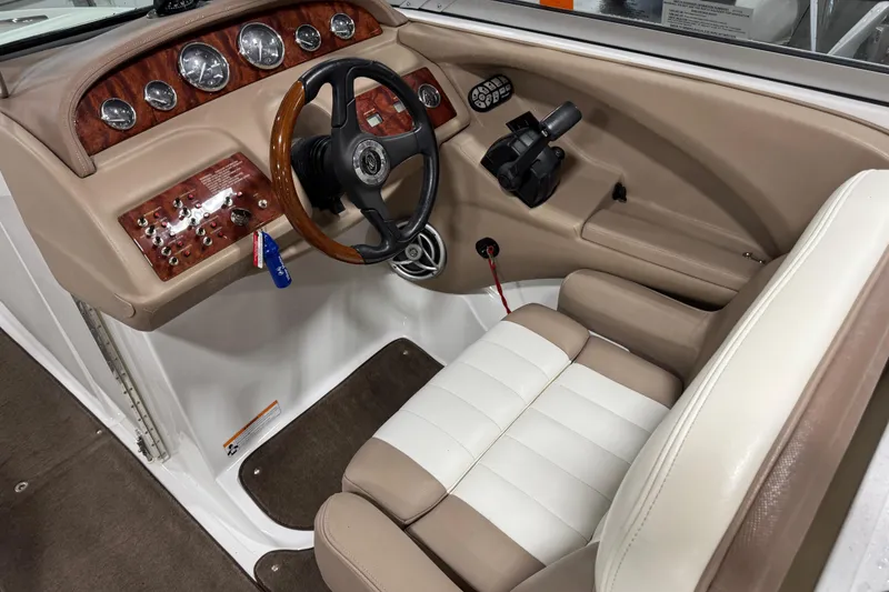 Slide: The Image of 2007 Cobalt 282 boat cockpit with wood-accented dashboard and beige leather seating. - 10