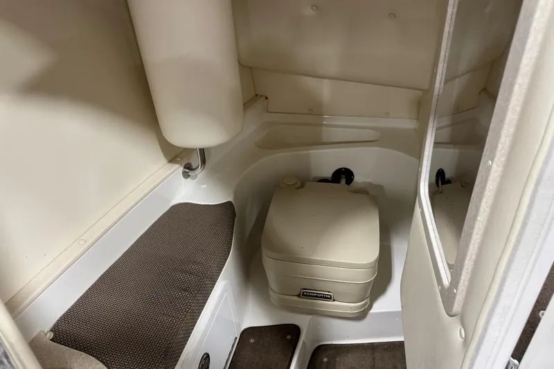 Slide: The Image of 2007 Cobalt 282 boat interior with compact marine toilet and cushioned seating. - 13