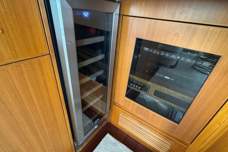 Slide: The Image of Wood-paneled interior of 2007 Jefferson Pilothouse 52 SE with wine cooler and control panel. - 14
