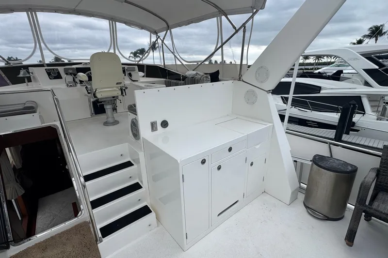 Slide: The Image of 2007 Jefferson Pilothouse 52 SE yacht deck with helm, seating, and storage cabinets. - 20