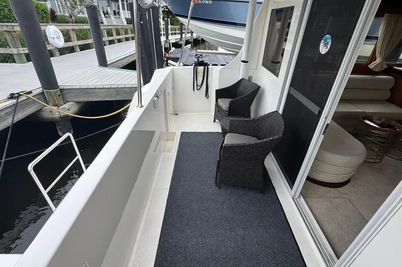Slide: The Image of 2007 Jefferson Pilothouse 52 SE yacht deck with wicker chairs and sliding door. - 8