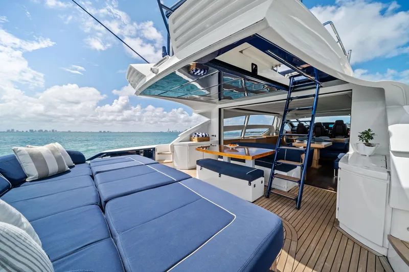 Slide: The Image of Luxurious 2013 Pershing 82 yacht with spacious deck, blue seating, and ocean view. - 17