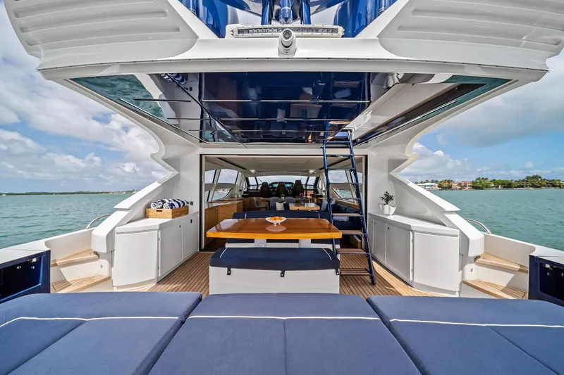Slide: The Image of Luxurious 2013 Pershing 82 yacht interior with elegant seating and dining area, overlooking serene waters. - 18