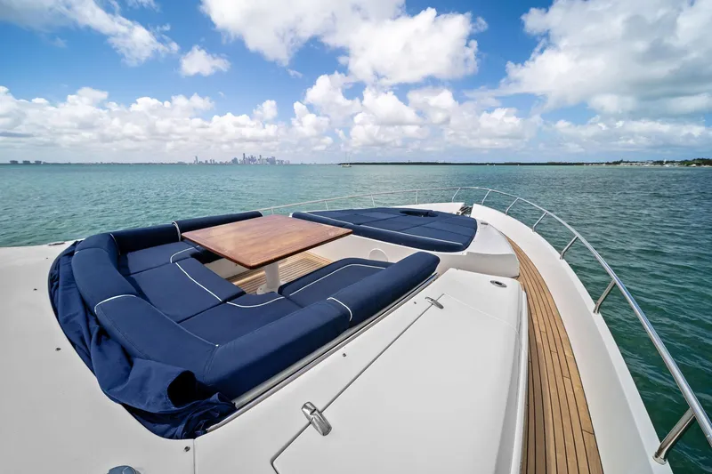 Slide: The Image of Luxurious 2013 Pershing 82 yacht deck with blue seating, wooden table, and ocean view. - 21