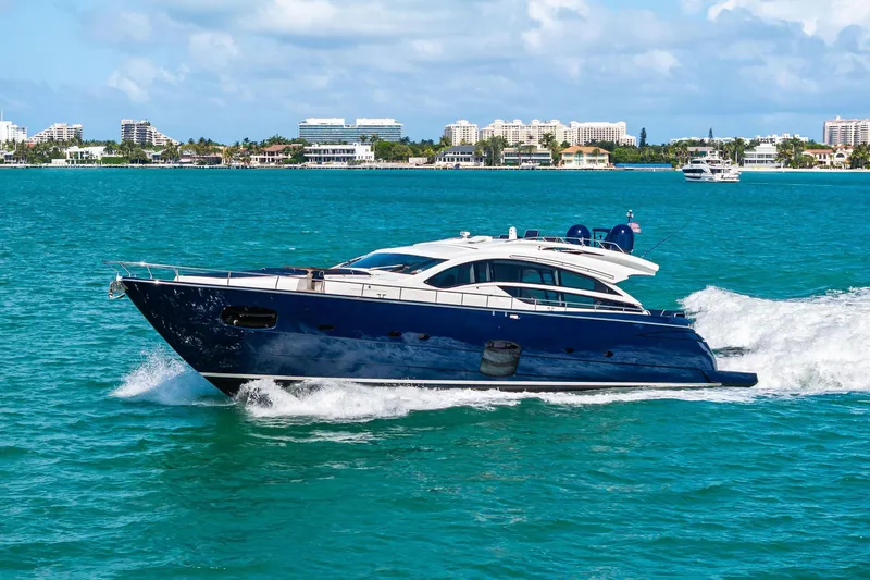 Slide: The Image of Luxurious 2013 Pershing 82 yacht cruising on turquoise waters near a coastal cityscape. - 3