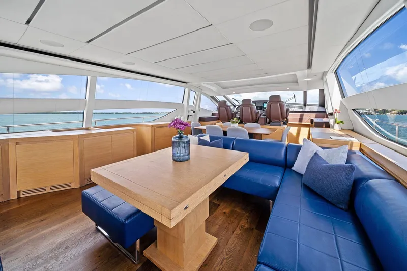 Slide: The Image of Luxurious interior of 2013 Pershing 82 yacht with blue seating and wooden table. - 30
