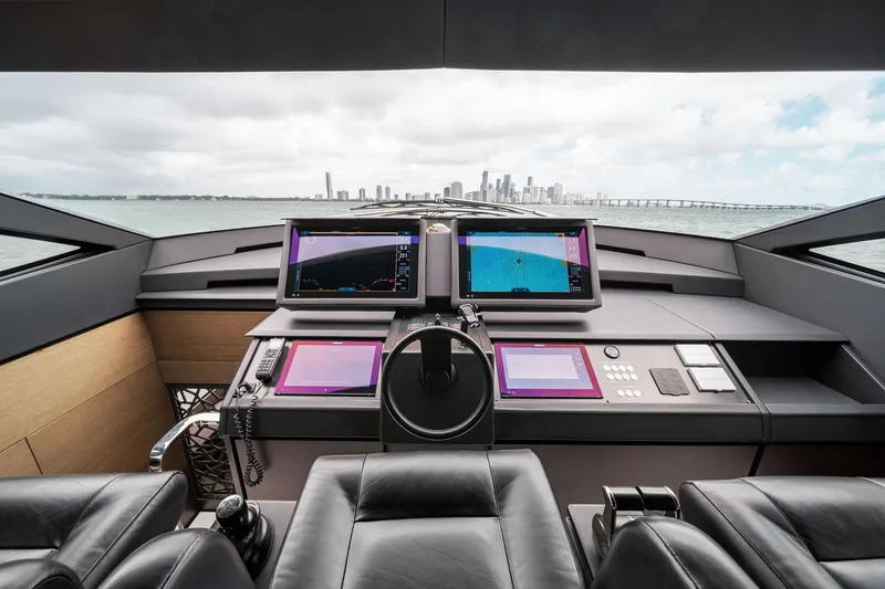 Slide: The Image of Cockpit of 2021 Pershing 8X yacht with navigation screens, overlooking city skyline. - 32
