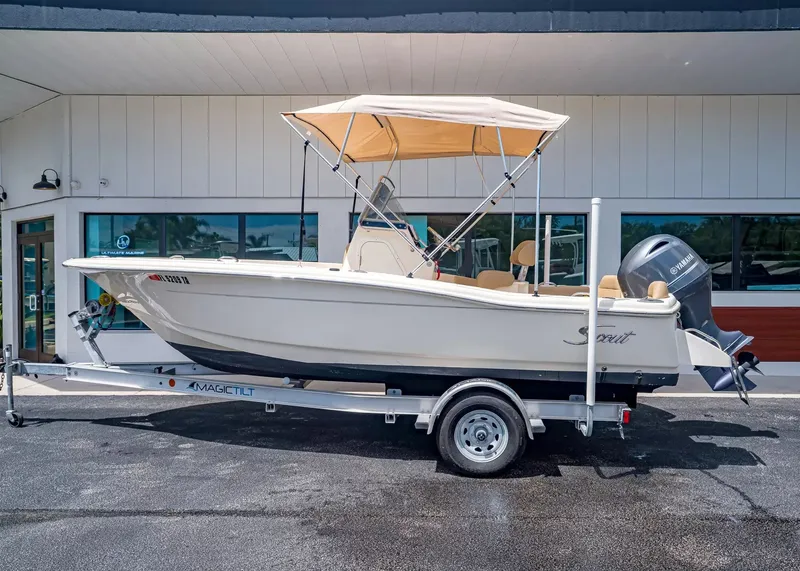 Slide: The Image of 2022 Scout 195 Sportfish boat on trailer outside building. - 2