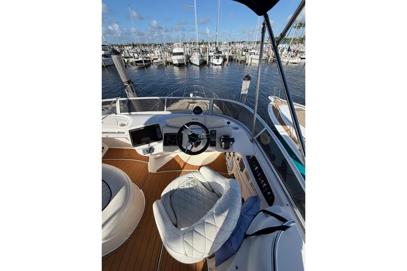 Slide: The Image of 2006 Meridian 341 Sedan helm with marina view, featuring luxurious seating and navigation equipment. - 13