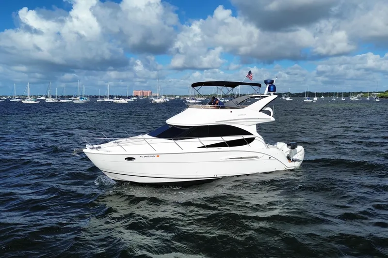 Slide: The Image of 2006 Meridian 341 Sedan cruising on a scenic, sunny waterway with sailboats in the background. - 3