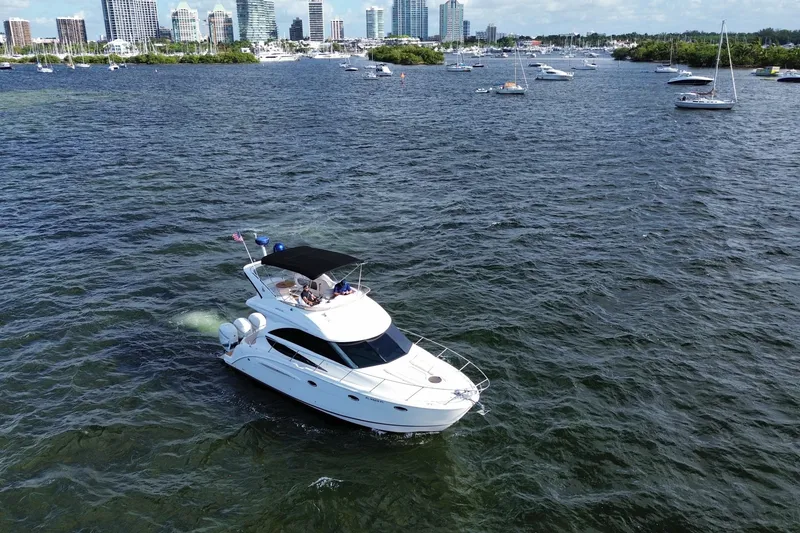 Slide: The Image of 2006 Meridian 341 Sedan yacht cruising near city skyline and anchored boats. - 6