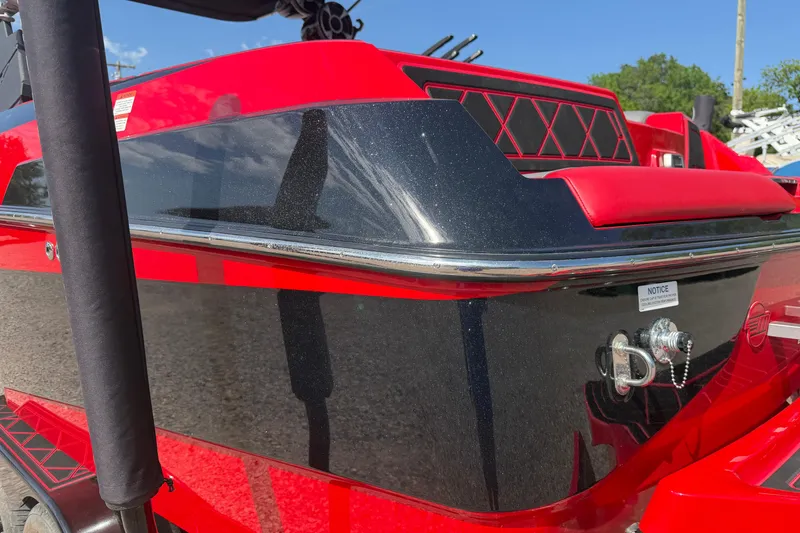 Slide: The Image of Red and black 2021 Malibu M220 boat with sleek design and chrome accents. - 10