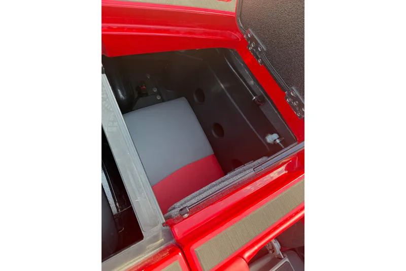 Slide: The Image of Storage compartment of a 2021 Malibu M220 boat, featuring red and gray interior. - 14